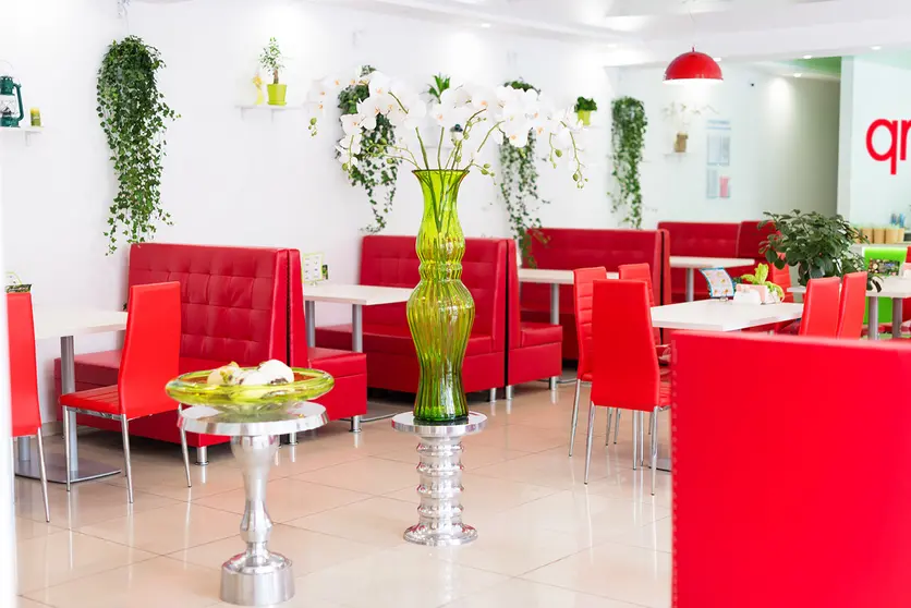 Modern design of restaurant interior in white and red colors with plants